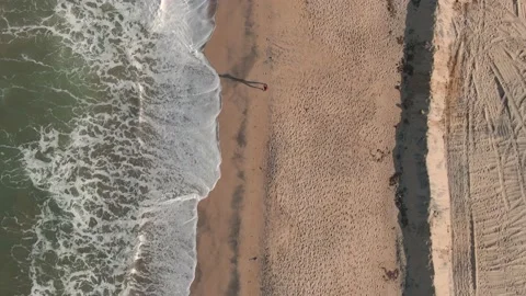 Arial Drone Shot of Person Running on The beach With Long Shadows Stock Footage 213959830