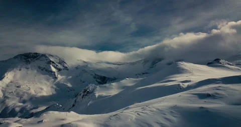 Arial drone shot of ski-slopes with mountain peaks in the background Stock Footage 131502565