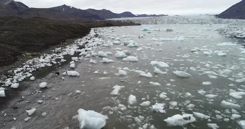 Arial of ice and iceberg moving with the waves on a arctic coast with glacier Stock Footage 146981663