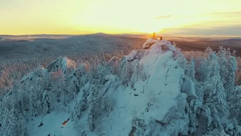 Arial view of A Man Standing On Top Of Mountain at sunset with the sun in the Video stock 102766734