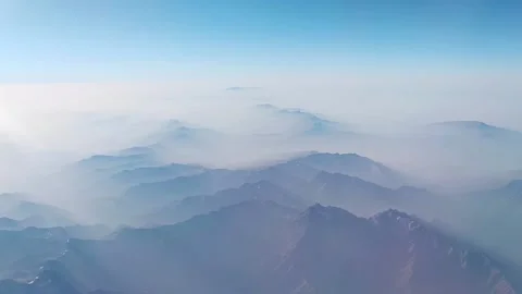 The arial view from the plane on the mountain ridge and the blue sky Stock Footage 221133535