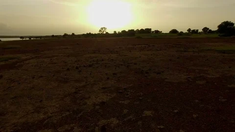 An arid African plain of red earth near a lake. The drone approaching. Stock Footage 71322174