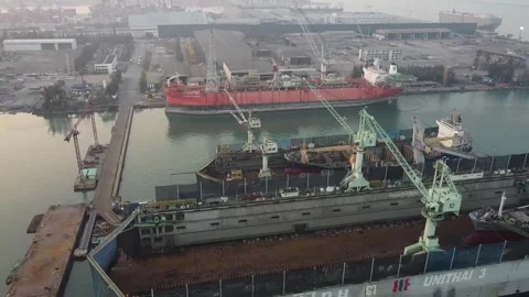 Ariel ascent drone dolly shot over maintenance cranes in dry dock misty Stock Footage 246785015