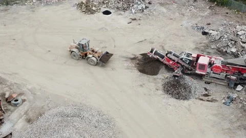 Ariel Drone Shot of Front Loader Unloading Stone Crushing Machine Stock Footage 194150545