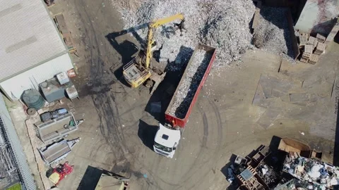 Ariel Drone Shot of Large Crane With Claw Unloads Used Tin Cans for Recycling Stock Footage 193996993