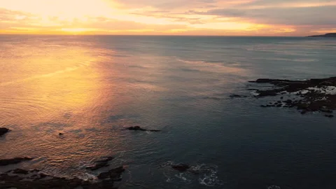 Ariel pan over ocean cliff at sunset Video stock 149284125