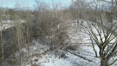Ariel pan snow covered river trees  in the winter time 4K Stock Footage 236410255
