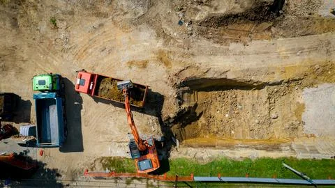 Ariel view excavator is loading a truck with ground on building site Stock Photos