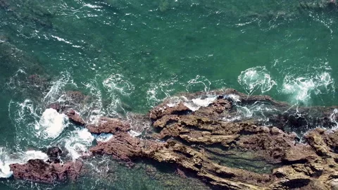 Ariel view of ocean waves crashing on rocky shore Video stock 149281380