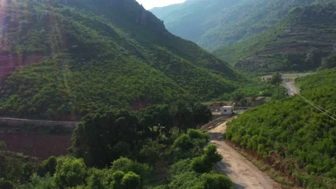 Ariel view of a road surrounded by green mountains Stock Footage 137381609