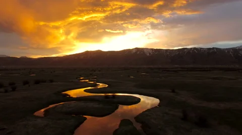 Ariel view of sunrise above winding river in Wyoming stock footage Stock Footage