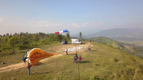 Ariel view two people having a lot of fun Paragliding taking off the cliff Stock Footage 98473429
