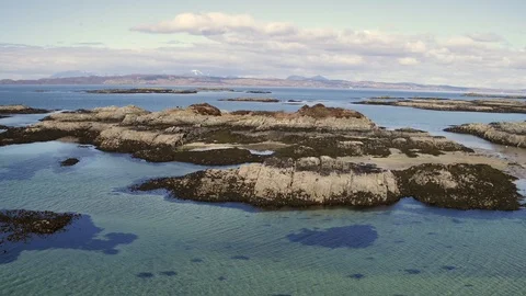 Arisaig beach emerging looking towards Skye. Aerial 4K Stock Footage 102807747