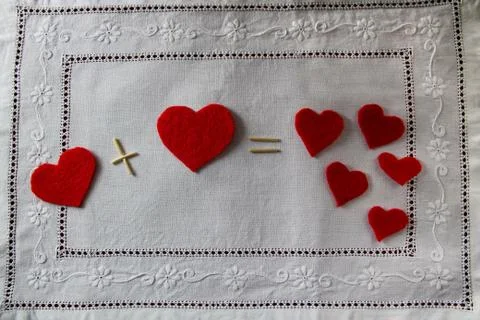 Arithmetic of love. Example with hearts on a white napkin with embroidery Stock Photos