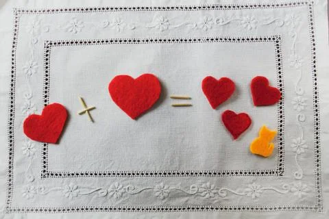Arithmetic of love. Example with hearts on a white napkin with embroidery Stock Photos