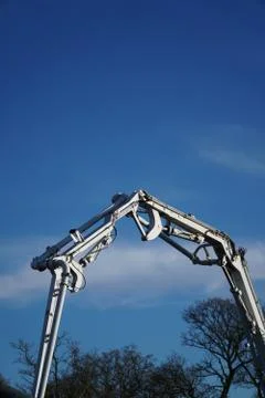 Arm of a concrete pump working on a construction site with a blue sky backgro Stock Photos