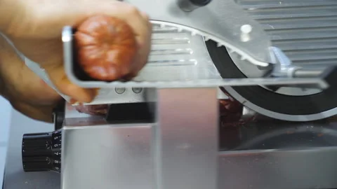 Arm of cook using cutting machine for salami at cuisine restaurant. Male hand of Stock Footage 329297384