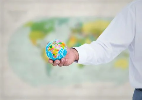 Arm with globe against blurry map 스톡 사진