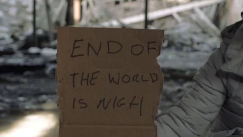 Arm holding sign warning of the end of world in rubble background Video stock 124721779