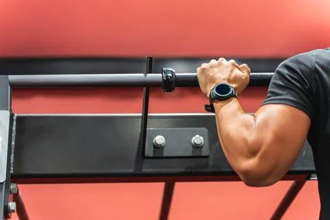 Arm of a man doing pull-ups with a smartwatch Stock Photos