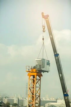 Arm of mobile construction crane is Installing yellow construction tower cran Stockfoto's