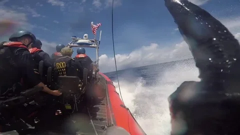 Armed Coast Guard's sailing in rigid inflatable boat Stock Footage 90335118