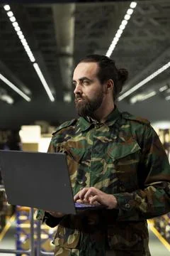 Armed forces personnel working inside military warehouse and managing cargo Stock Photos