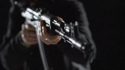 Armed man in black simulates shooting a machine gun. Bandit with weapons in hand Stock Footage 83000935