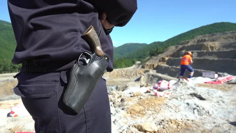 An armed man looking workers mining on a quarry Stock Footage 232582954
