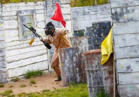 Armed man setting up victory flag in paintball mission Stock Photos