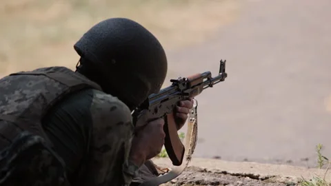 Armed man unloading machine gun with machine gun in his hands, soldier lying 스톡 동영상 217372342