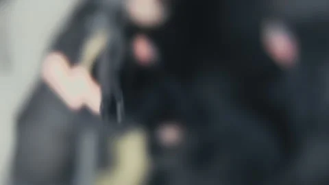 Armed security contractor holds AR15 barrel to camera with a shallow DoF Stock Footage 133546332