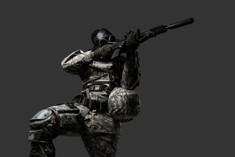 Armed soldier of african descent aiming rifle against dark background Фото