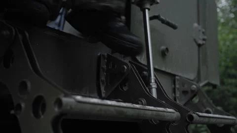 Armed soldier in camouflage getting out of a military transport Stock Footage 327457819