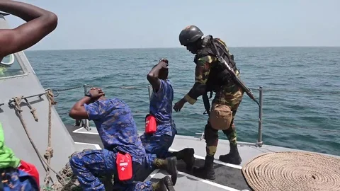Armed soldier orders suspect smugglers to kneel during Exercise Obangame Express Vídeos de archivo 105646827