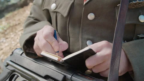 Armed soldier write into small notepad close-up 4K Stock Footage 139065529