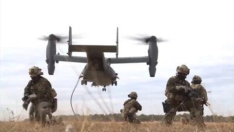 Armed soldiers kneeling while V-22 Osprey hovers Stock Footage 88579730