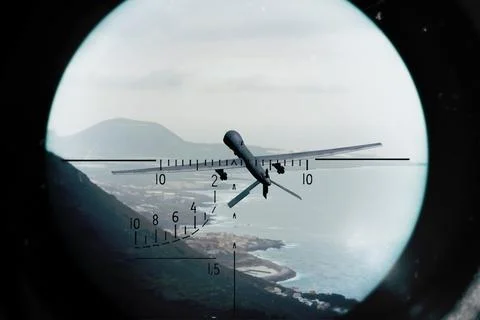 An armed strike drone flies over coastline and is tracked by a targeting syst Fotos de archivo