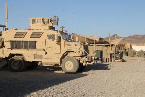 Armored vehicles standing ready on base in middle east desert (HD)c Stock Photos
