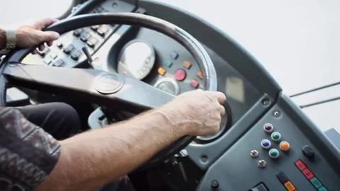 Аrms of bus driver turns the steering wheel closeup Stock Footage 82697137