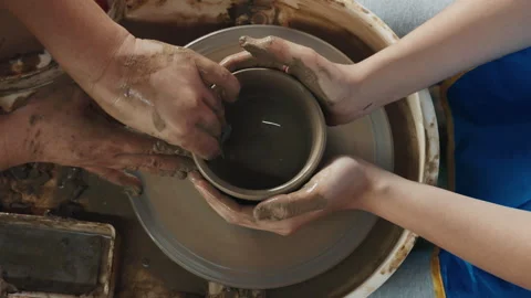 Arms of two people working on shape of raw clay container Stock Footage 304223229