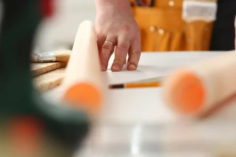 Arms of worker making structure plan on scaled paper closeup Stock Photos