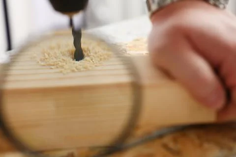Arms of worker using electric drill closeup Stock Photos