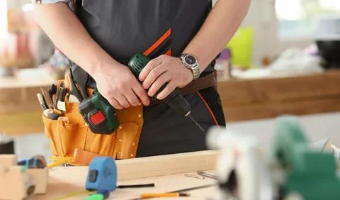 Arms of worker using electric drill 스톡 사진