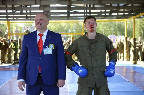 Army combative. Referee announcing the winner fighter in a ring. An exhibitio Stock Photos