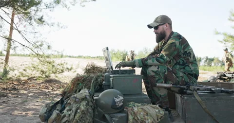 Army commander sits behind computer in field and creates reports to be sent to Stock Footage 169380761
