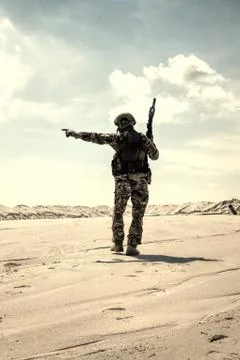 Army commando soldier observing sandy desert area Foto stock
