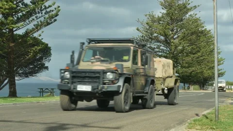 Army jeep driving through Australian coastal town Stock Footage
