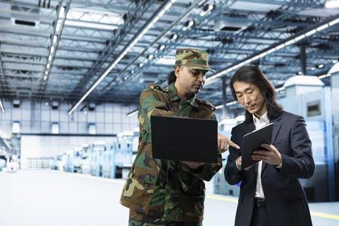 Army man and manager use laptop to increase semiconductor self sufficiency Stock Photos