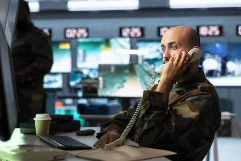 Army operator reporting to military generals during telephone call Stock Photos